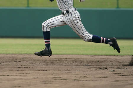 Baseball player attempting to steal a base during a baseball game.の写真素材