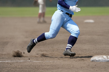 Runner trying to get to the next base during a baseball gameの写真素材