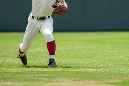 A player defending the outfield during a baseball game sends a pitchの写真素材