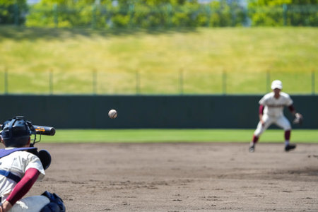A shortstop protecting the infield and the ball hit by a batter during a baseball game.の写真素材