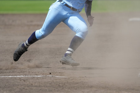Runner trying to get to the next base during a baseball gameの写真素材