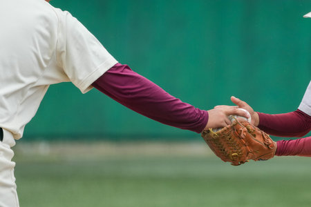 Handing the ball to a player for a pitcher change during a baseball game.の写真素材