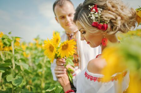 Wedding beautiful couple in traditional dress at the sunflower