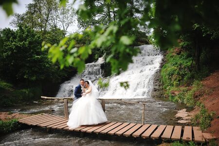 beautiful wedding couple near waterfallの写真素材