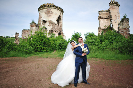 beautiful wedding couple near ruins tower of old castleの写真素材