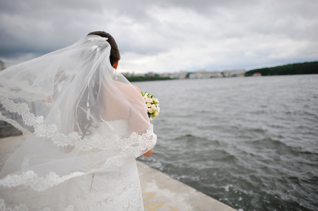 Bride on the windy weather  near the lakeの写真素材