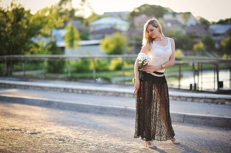 Girl with flowers on sunsetの写真素材