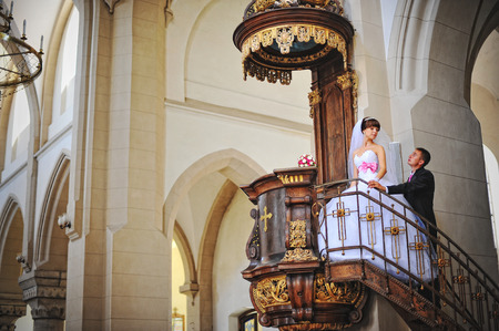 Young beautiful wedding couple at the old catholic churchのeditorial素材