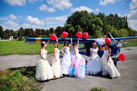 funny brides with balloons at the hand on the airportの写真素材