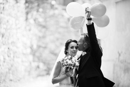 Happy wedding couple with balloonsの写真素材