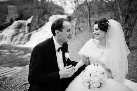 lovely newlyweds background waterfall at cold autumn dayの写真素材