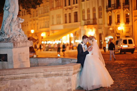 wedding couple in love on streets of evening Lviv, Ukraineの写真素材