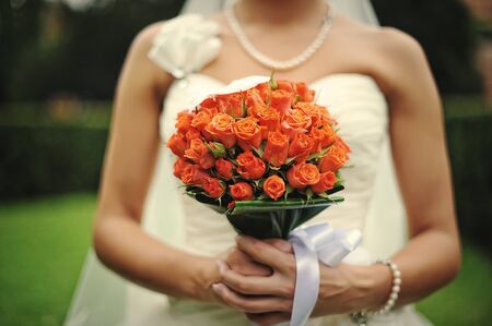 Brunette bride with wedding bouquet on handの写真素材
