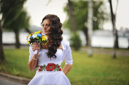 Brunette girl with bouquet on traditional dress