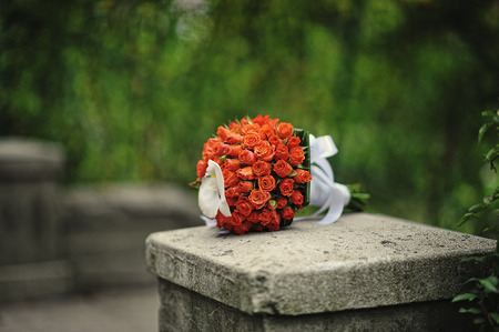 Red and orange wedding bouquet of rosesの写真素材