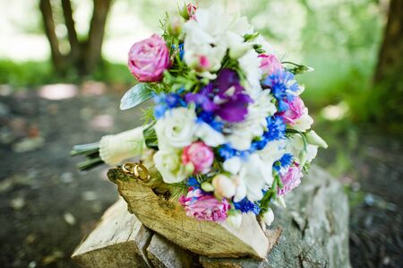 Wedding bouquet with rings on wooden forestの写真素材