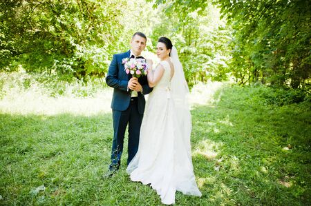 Gorgeus wedding couple on green sunny forestの写真素材