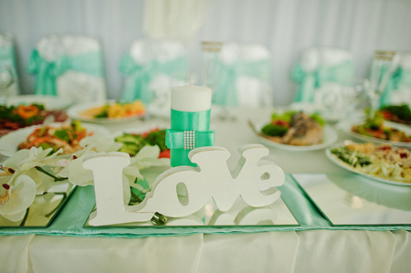 Decor word love on mirror and candle on wedding tableの写真素材