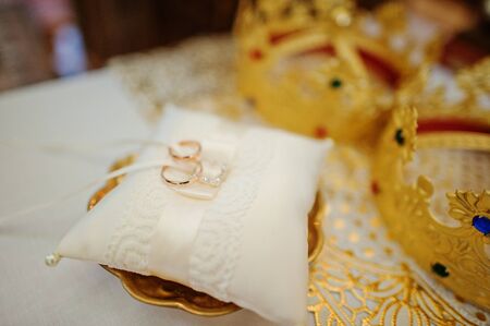 wedding ring on pillow near crown of newlywedsの写真素材