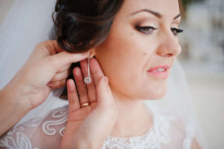 Young brunette bride wear earringsの写真素材