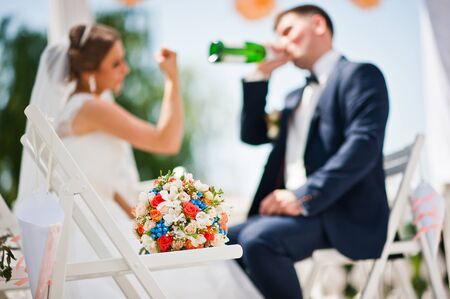 drinking champagne groom, focus on bouquetの写真素材