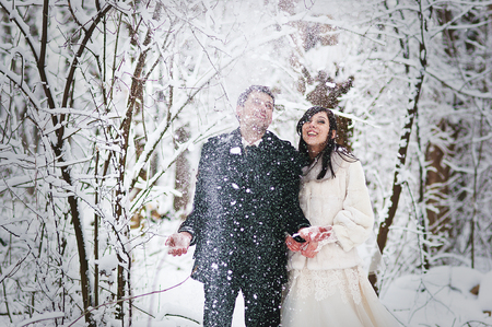 Wedding couple in winter snowly forestの写真素材