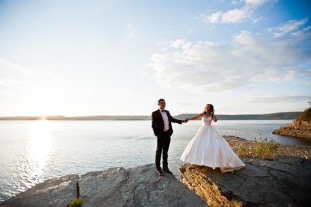 Very sensual and gorgeus wedding couple on the picturesque landscapes on sunsetの写真素材