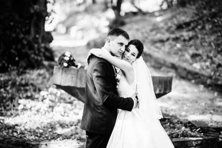 Gorgeous wedding couple at autumn park in loveの写真素材