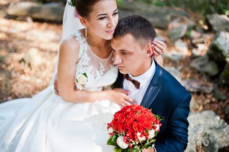 Gorgeous wedding couple at autumn park in loveの写真素材