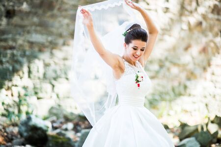 Elegant brunette bride with long veil at the forestの写真素材