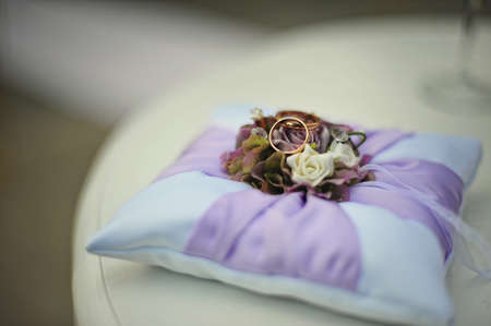 Purple pillow with wedding ringsの写真素材
