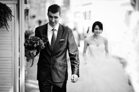 Groom walk with bouquet in hand background brideの写真素材