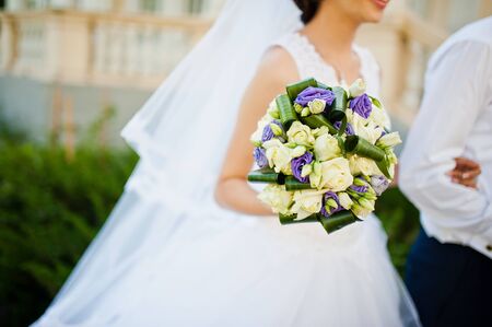 Violet wedding bouquet on hand of brideの写真素材