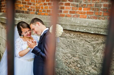 Wedding couple near old wooden door of catholic churchの写真素材