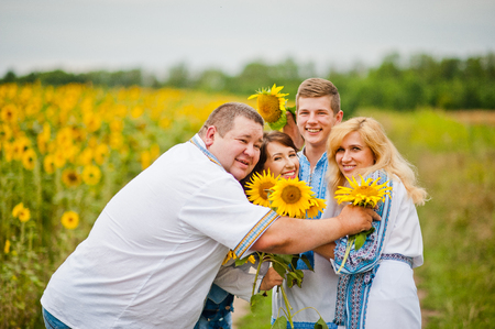 Happy family having fun on sunflowersの写真素材