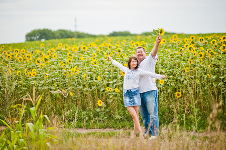Happy family having fun on sunflowers, father with daughterの写真素材