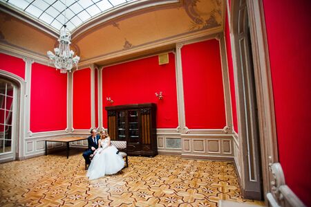 Elegant wedding couple at old vintage house and palace at red roomの写真素材