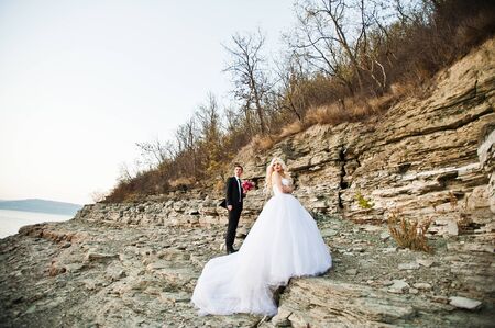Charming bride and elegant groom on landscapes of mountains and rocksの写真素材