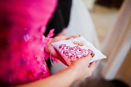 Bridesmaid holding little pillow with wedding ringsの写真素材