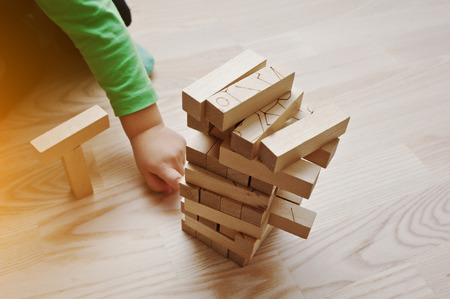 Hand of baby who played developmental game of wooden blocks lumberの写真素材