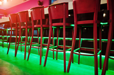 Red bar stools at diode color lightの写真素材
