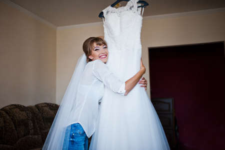 Youn happy bride looked at her wedding dressの写真素材