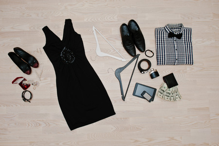 Set of trendy clothes. Outfit of man and woman clothes and accessories on light wooden backgroundの写真素材