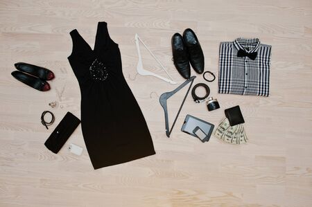 Set of trendy clothes. Outfit of man and woman clothes and accessories on light wooden backgroundの写真素材