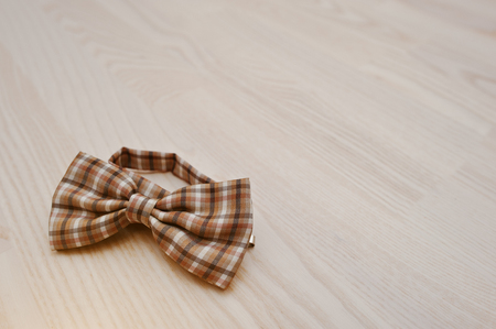 Brown checkered bow tie on light wooden backgroundの写真素材