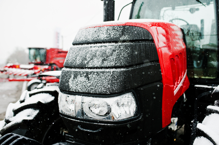 Close up in front of the new red tractor at snowy weatherの写真素材