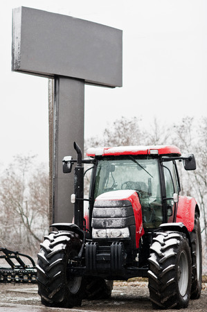 New red tractor at snowy weather background bannerの写真素材