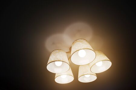 Included chandelier lamp at black ceilingの写真素材