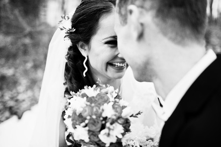 Very close up look of bride and groom with small orange wedding bouquetの写真素材