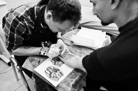 Tattoo master make tattoo for rocker man at tattoo salonの写真素材